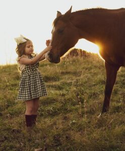 Ein kleines Mädchen mit einem Pferd (Bild)